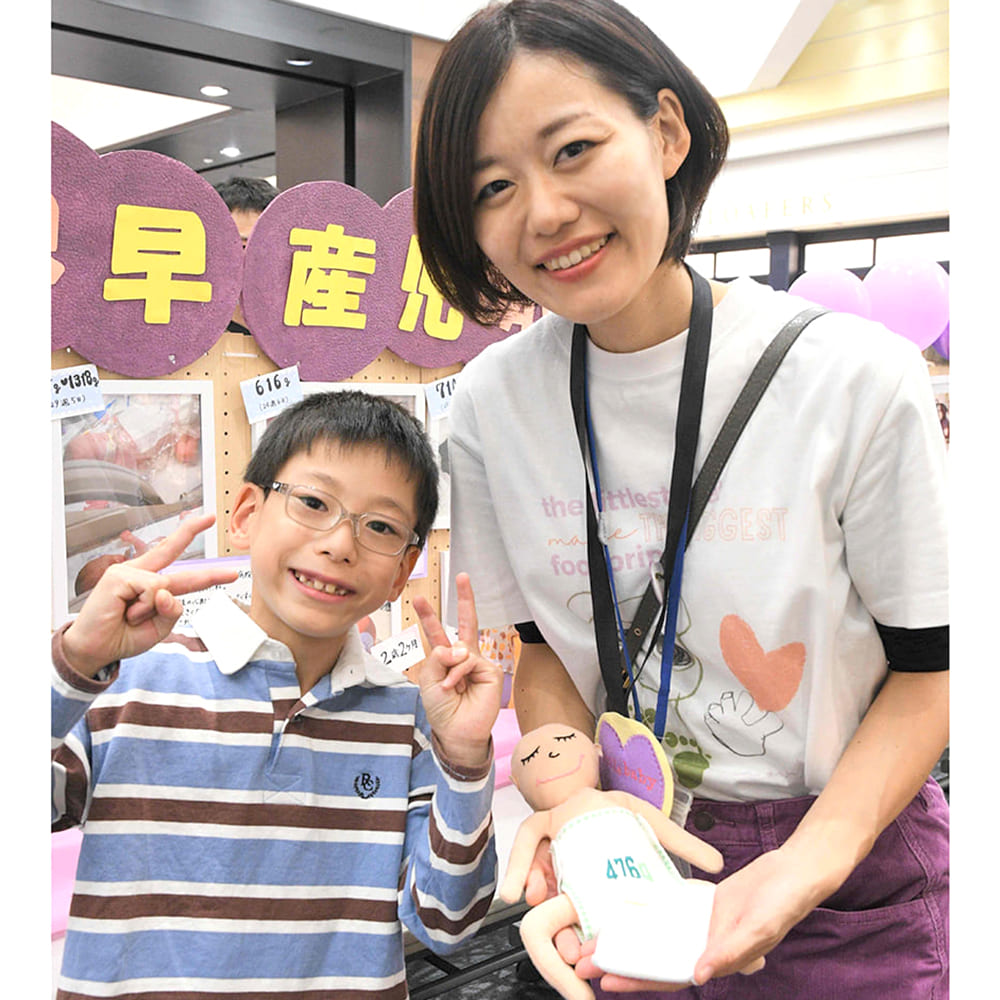 ウエイトドールを抱く五島さんと息子さん